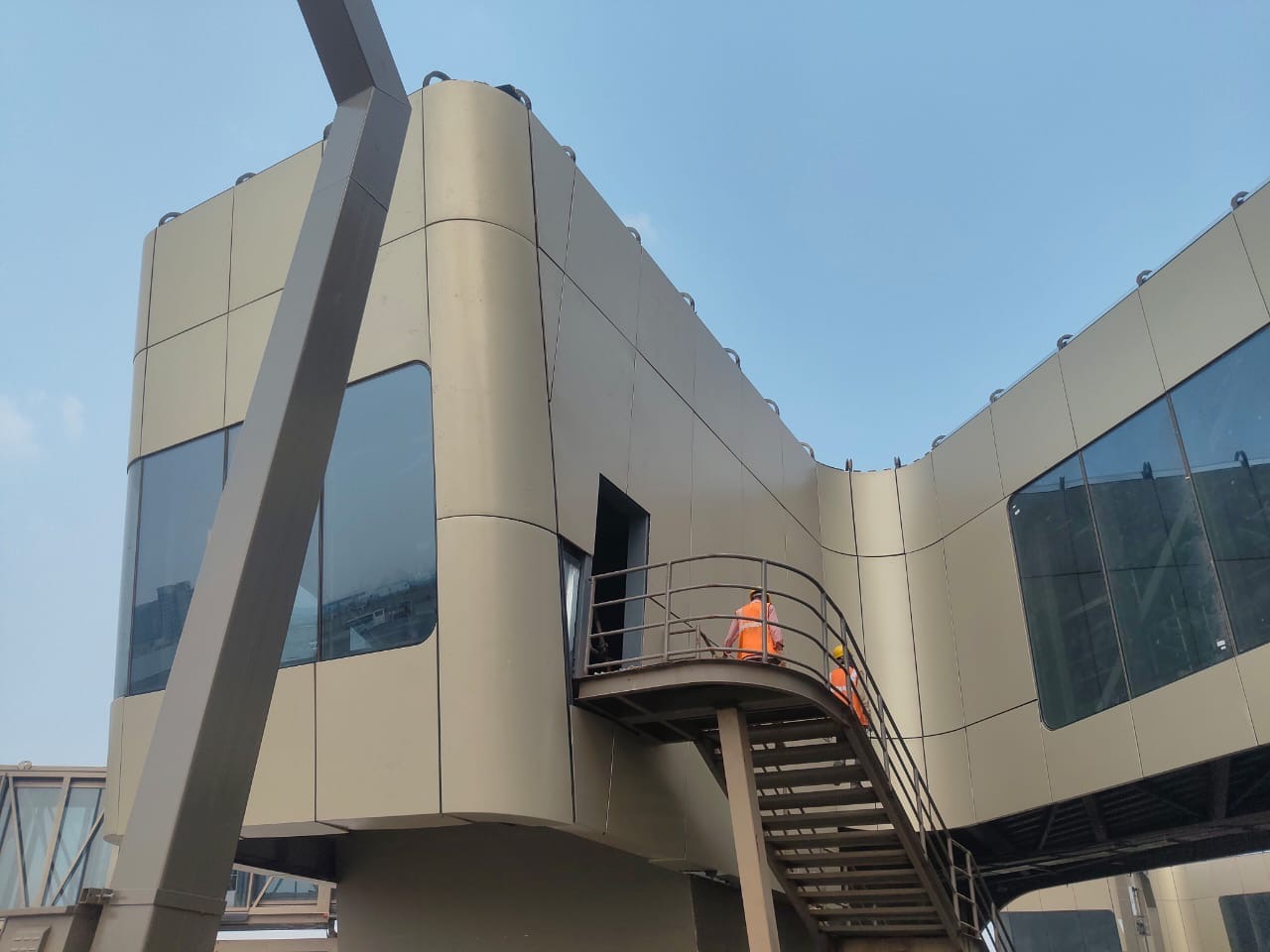 Workers installing high-level terminal cladding from an access platform