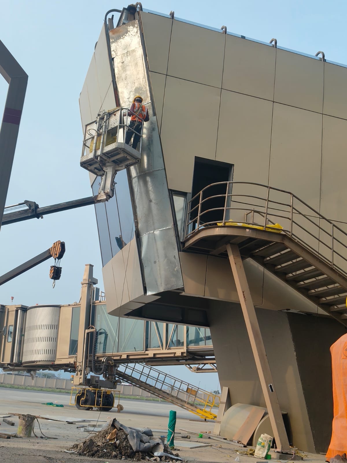 Worker on an elevated platform working on terminal facade cladding