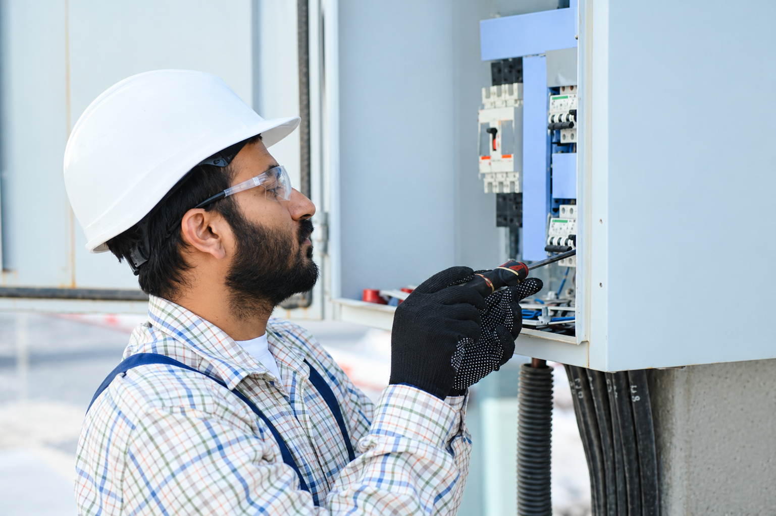 Electrician inspecting an electrical control panel